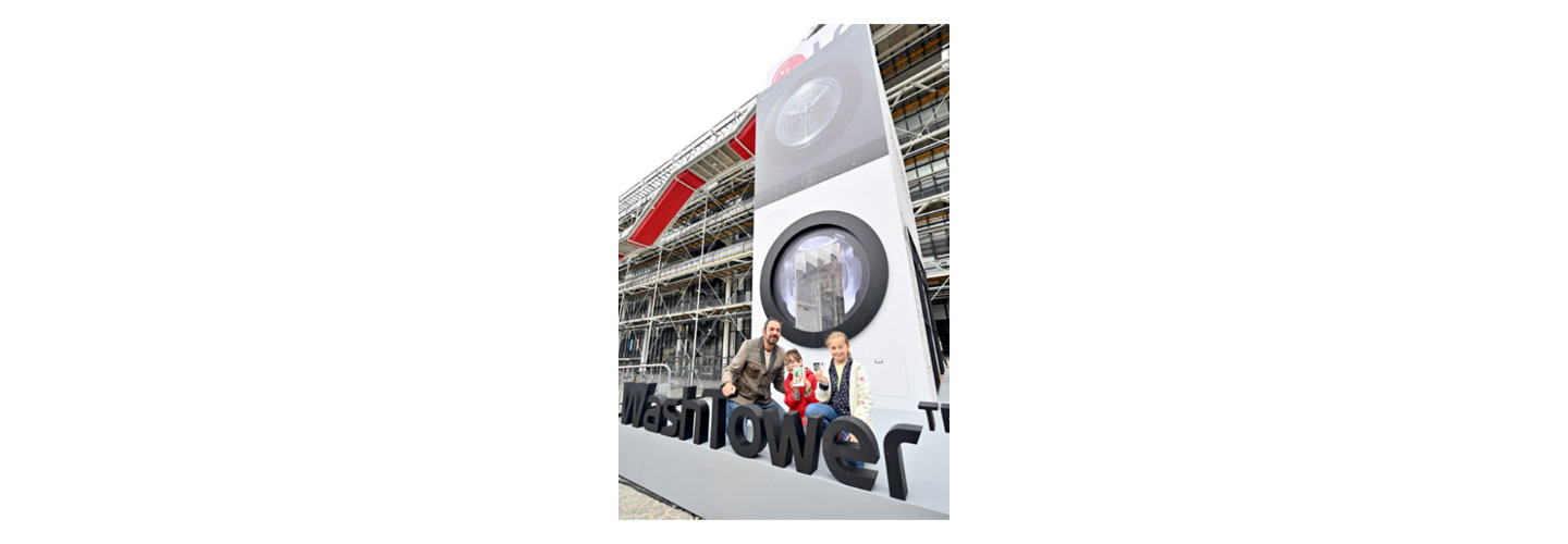 A family posing for a photo in front of a giant WashTower structure installed at Paris