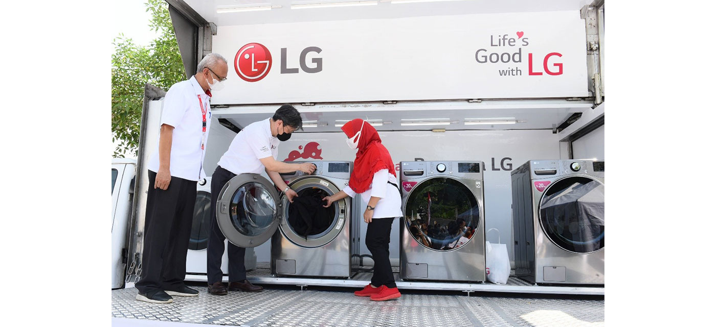LG Staff demonstrating how to use LG washer and dryer installed on a truck