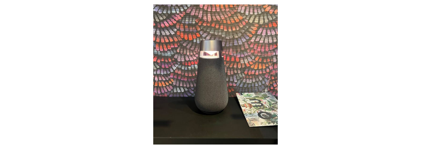Close shot of LG XBOOM 360 speaker pictured on top of a desk at LG's booth at IFA 2022
