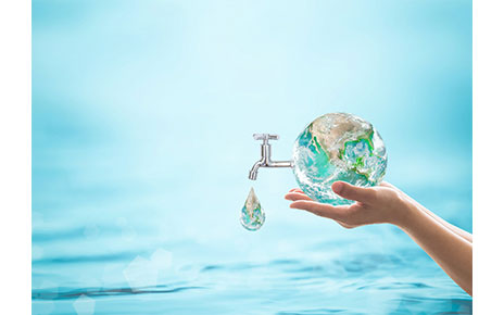 A human hand holding a ball shaped liked Earth with a faucet