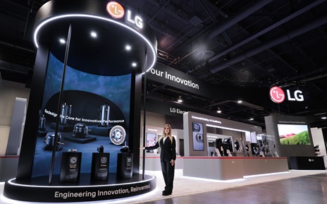 A woman demonstrates next-generation compressor and motor technologies in front of a large display in the AHR Expo hall.