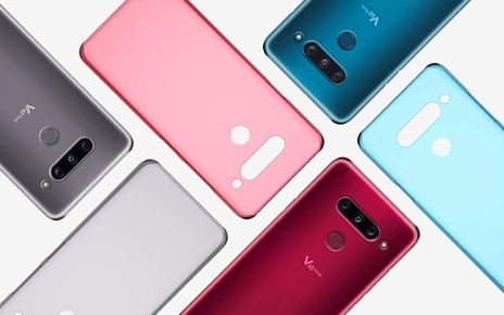 Three LG V40 ThinQs face down on a table with back cases positioned in a brick pattern.