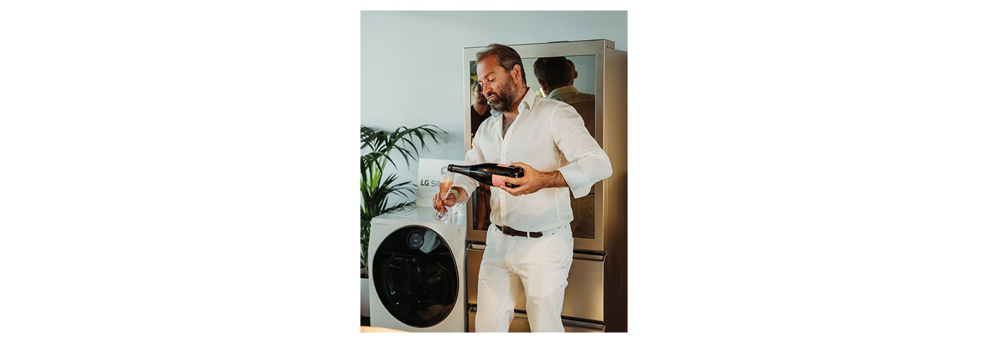 Tom Harrow, wine director of Honest Grapes pouring a glass of champagne at the prestigious party