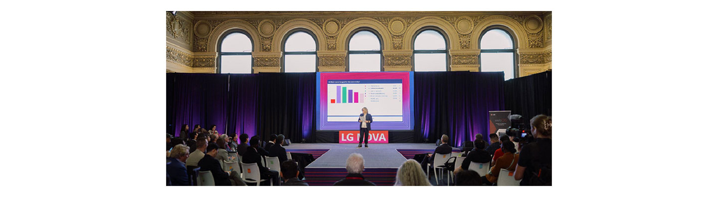A photo of Annie Hanlon, Emerging Tech Executive and Producer at Alchemy Tech & Entertainment Group, standing and talking on the stage
