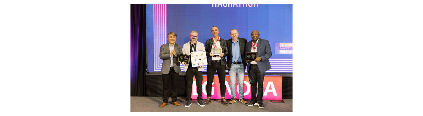 A photo of the winners of the webOS Hackathon standing next to each other posing for the camera with their awards