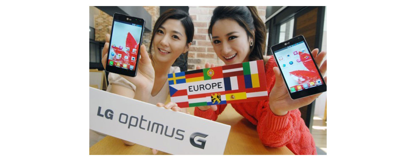 Two women show off LG Optimus G while holding up many European flags