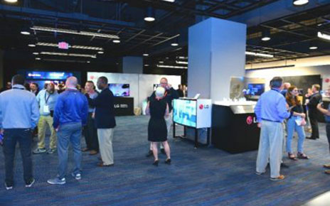 A looking inside the 2019 LG TechTour’s venue, with attendees browsing and discussing LG’s B2B products