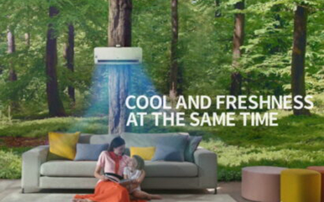 A picture of woman and child reading a book as they sit under LG DUAL COOL, as if they’re sitting in the middle of a dense forest