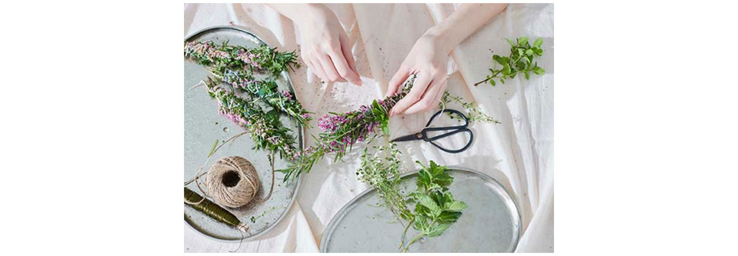 A person is making some decorations using flowers and plants