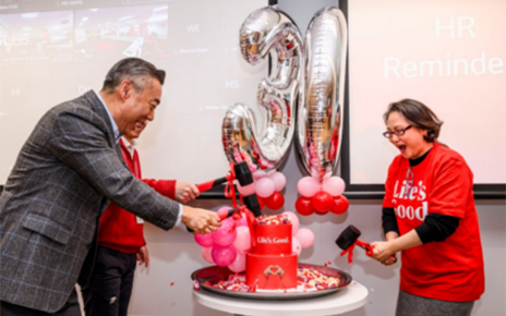 A picture of LG employees cutting the cake together