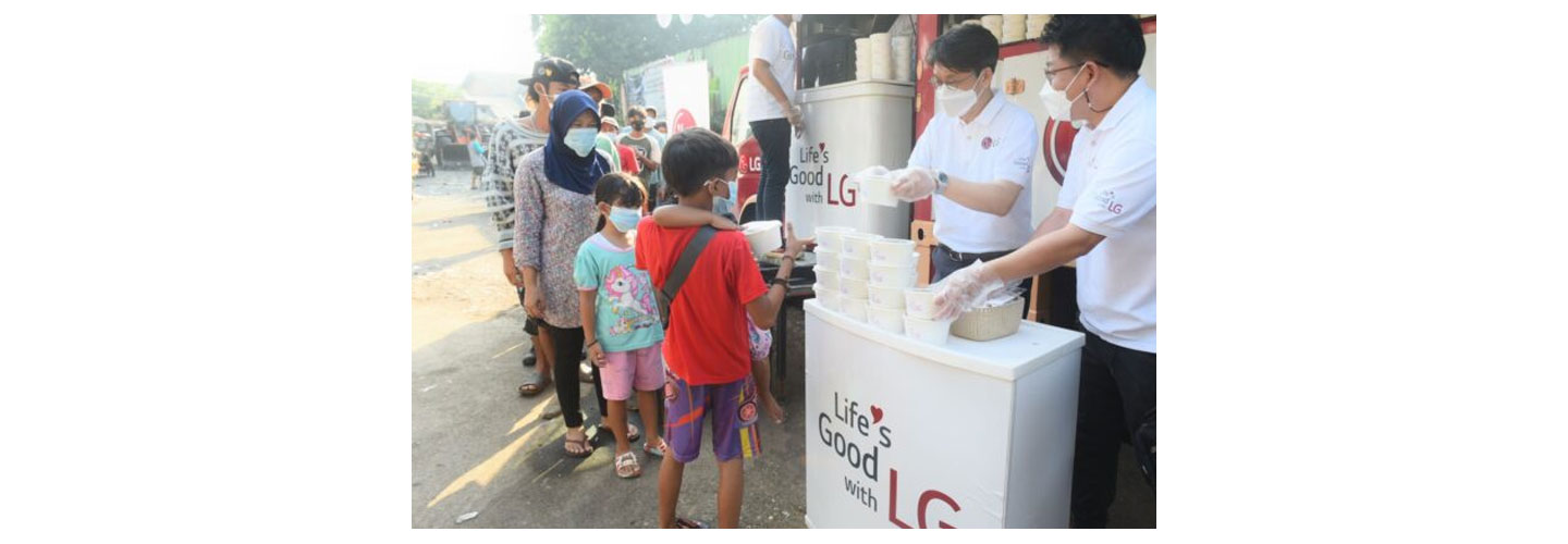 Lee Taijin, President of LG Electronics Indonesia, and Kris Lee, Product Marketing Director of Home Appliances LG Electronics Indonesia, serving food to people in Jakarta