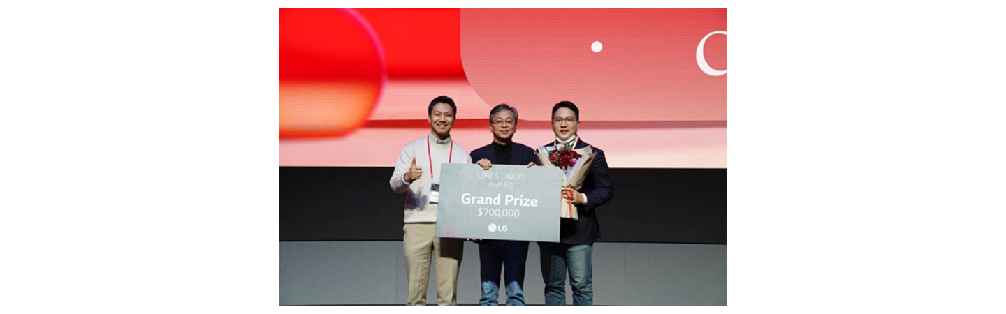 Dot Inc.’s Ki Kwang Sung and Ju Yoon Kim posing with LGE CSO Lee Sam-soo while holding a card representing the $700,000 prize money.