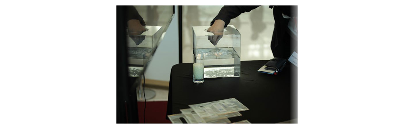 SOLUTUM’s booth at the LIFE’S GOOD AWARD Conference, with a representative demonstrating the solution degrading in water.