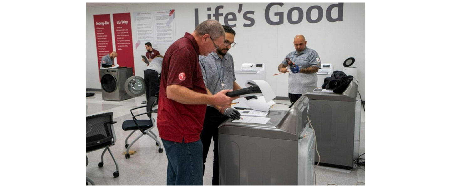 A photo of LG Service Managers gathered around a washer and dryer