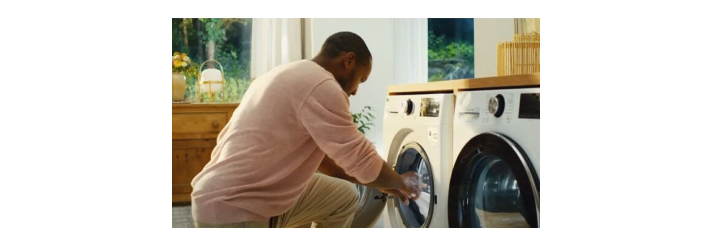 A man taking clothing out of his LG washing machine