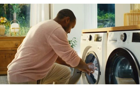 A man taking clothing out of his LG washing machine