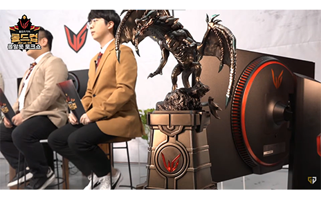 The LG UltraGear LoL Cup tournament trophy in the form of a dragon with the UltraGear monitor and e-sportscasters behind.