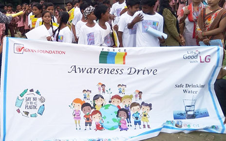 A group photo of participants of the LG Eco Agents of Change campaign holding a banner with an illustration that promotes the importance of young people when it comes to conserving the environment.