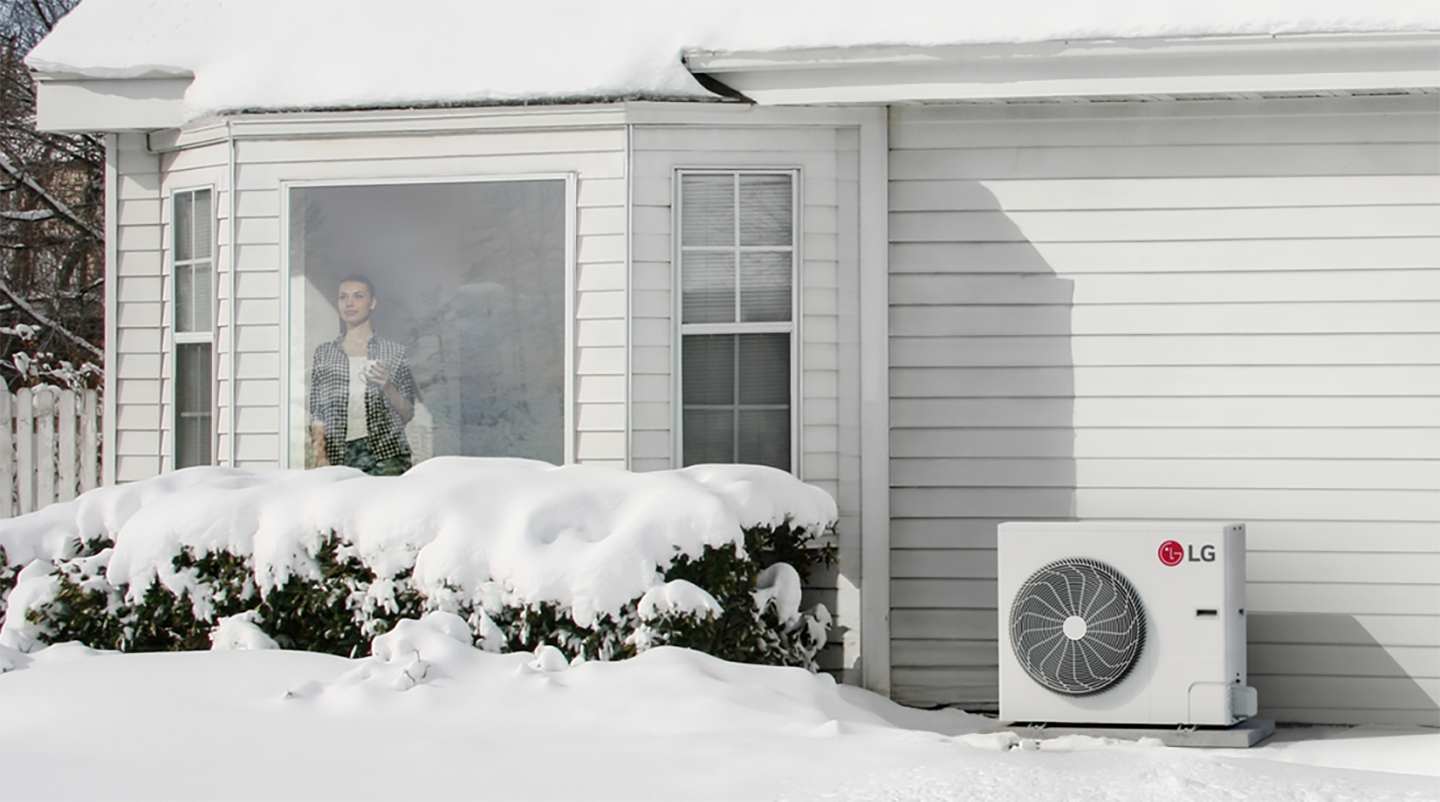 A view of the snow outside the home with LG HVAC products in front of the home