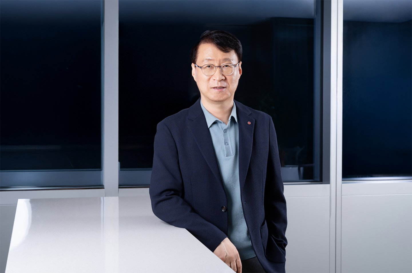 A photo of James Lee, President of LG Electronics ES Company, leaning one arm on the table and smiling