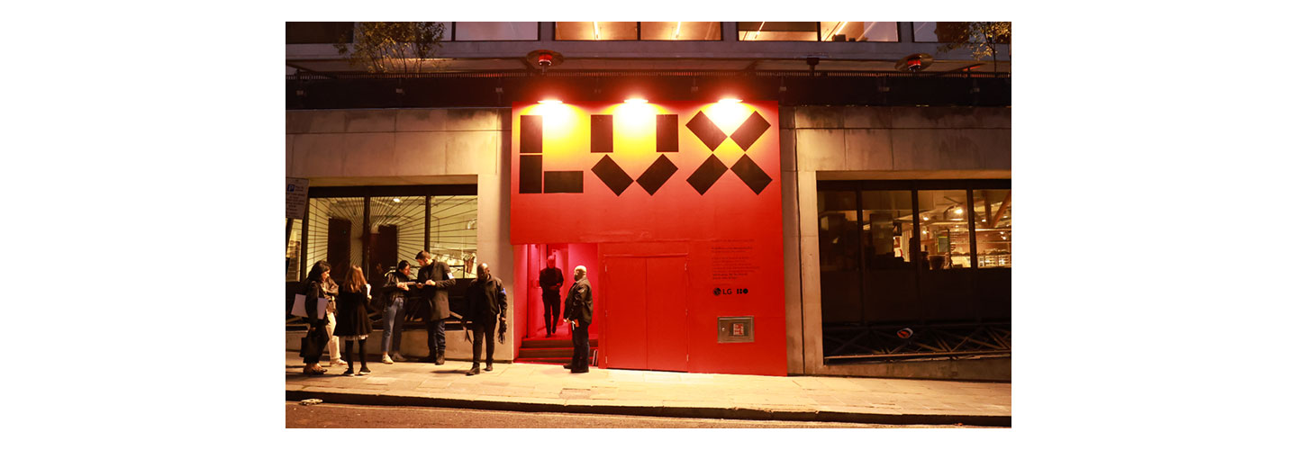 Visitors queued in front of a building’s entrance painted in red, waiting to view a special exhibition
