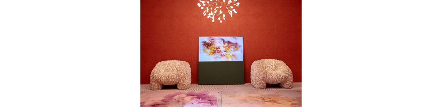LG OLED TV placed between two fluffy chairs