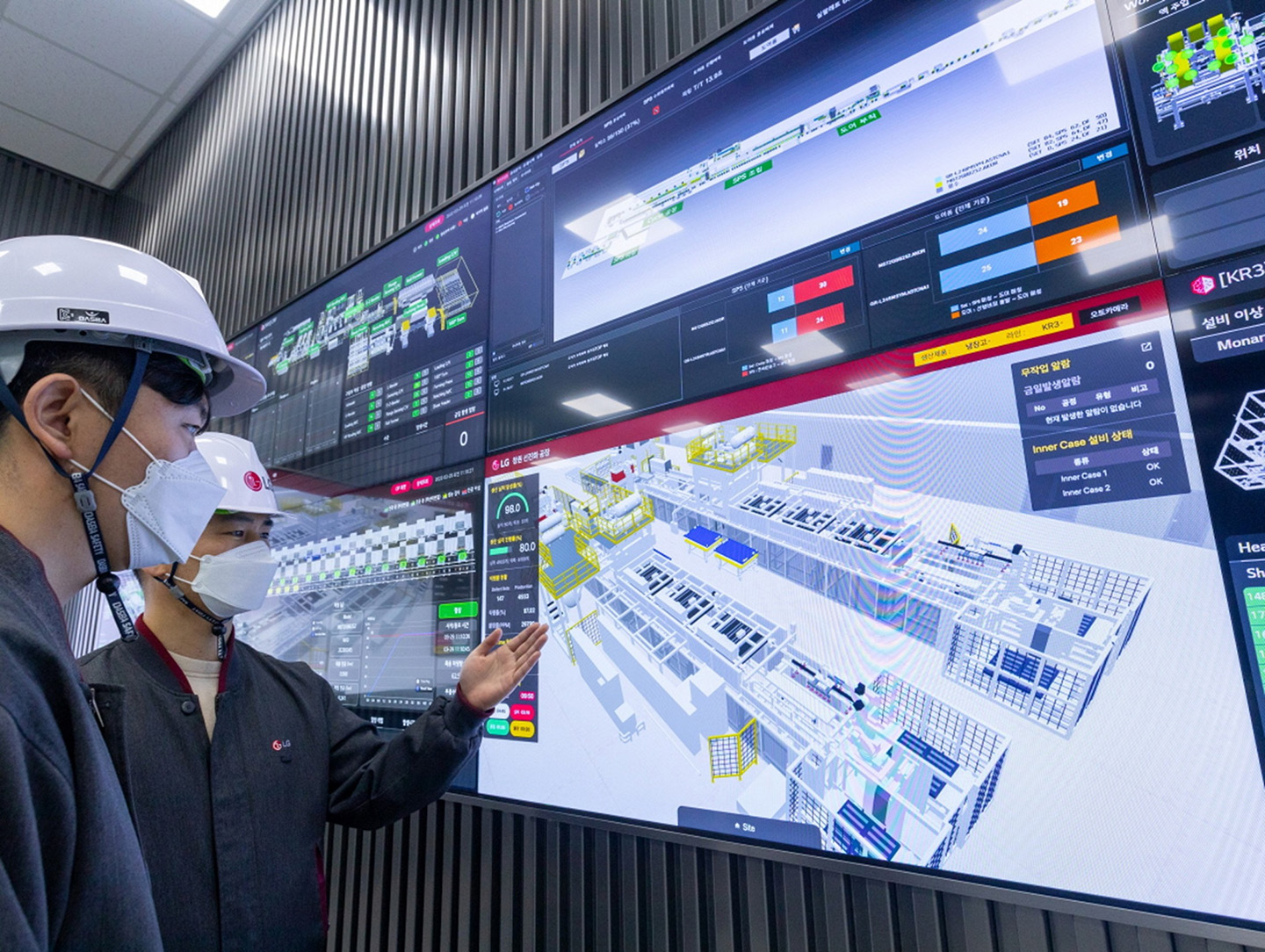 A photo of two factory workers observing an image of factory layout