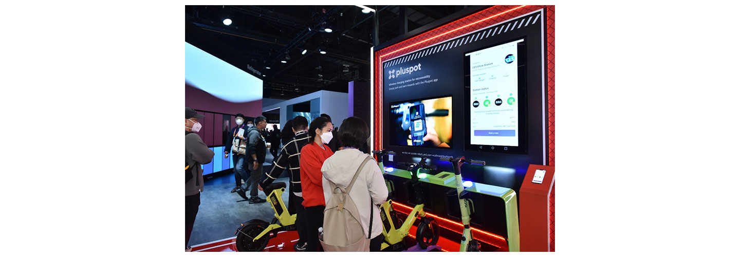 A corner of LG's booth with pluspot's products during CES 2023 where a staff is explaining features of the product to a visitor