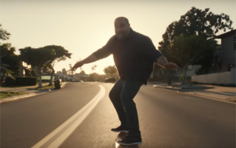 Middle aged man riding a longboard