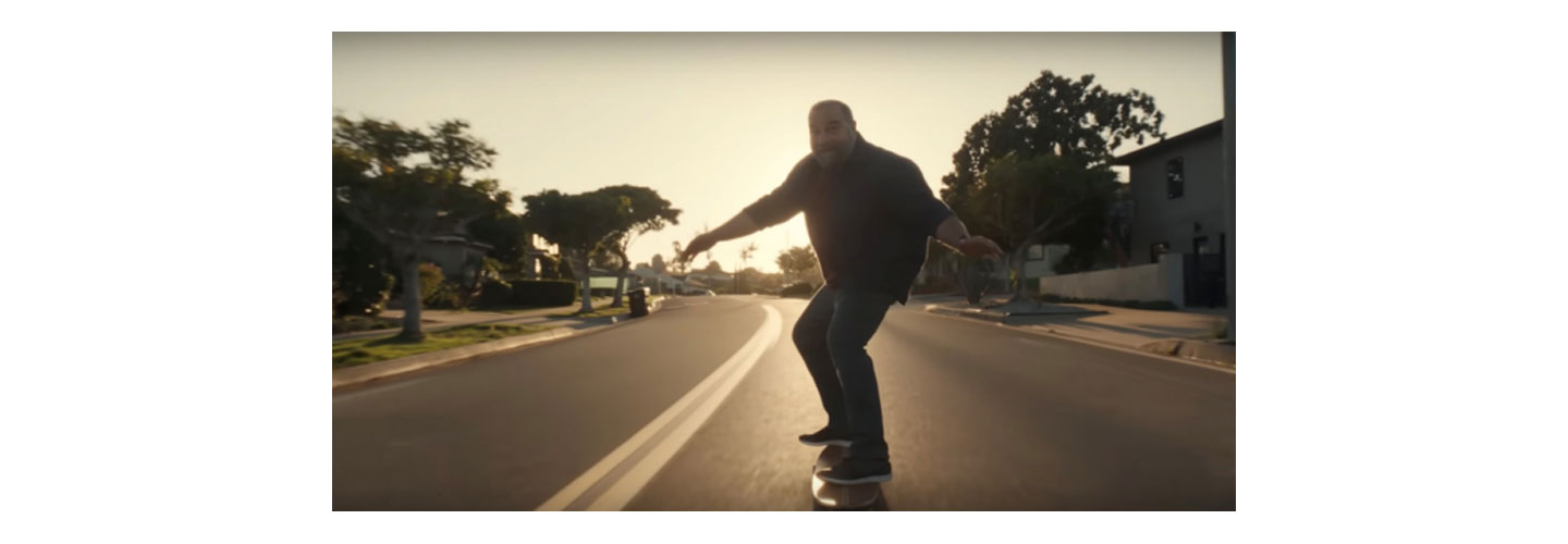 Middle aged man riding a longboard