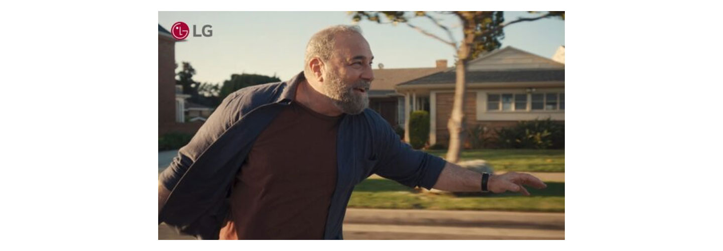 A closeup photo of an old man riding a longboard