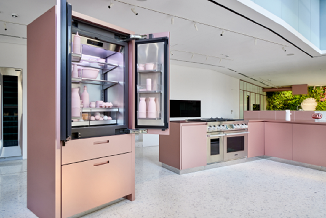 A picture of a kitchen space with pink appliances and an open pink refrigerator