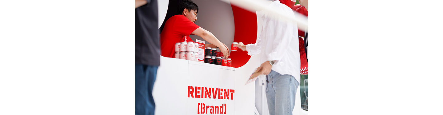 A staff handing out a coffee can to the visitor of the Life's Good event