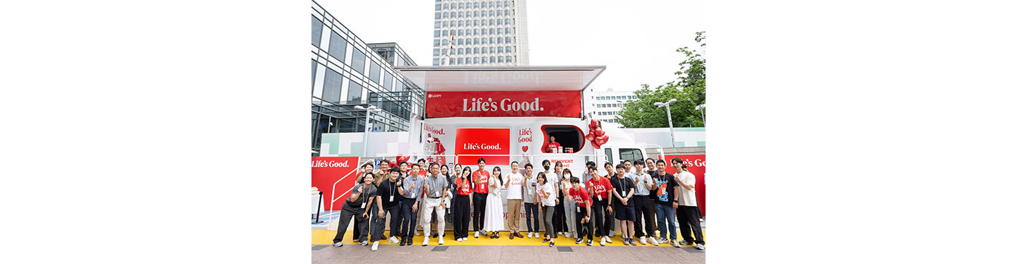 LG CEO and employees posing together for a photo in front to the Life's Good event truck 