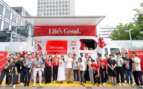 LG CEO and employees posing together for a photo in front to the Life's Good event truck 