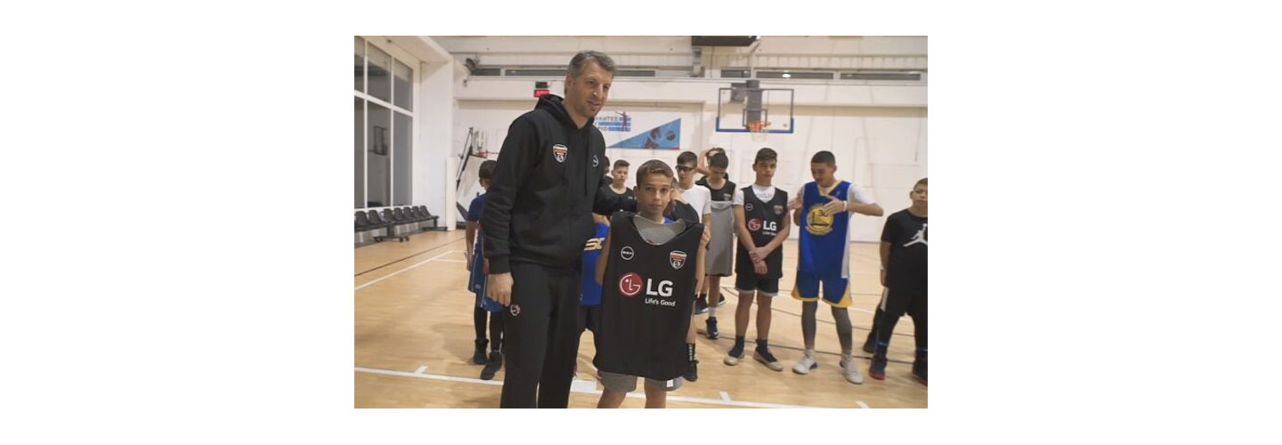 Participants of the LG Skills & Drills Contest watch on as one of the kids holds up an LG-branded jersey next to Greek basketball legend Thodoris Papaloukas