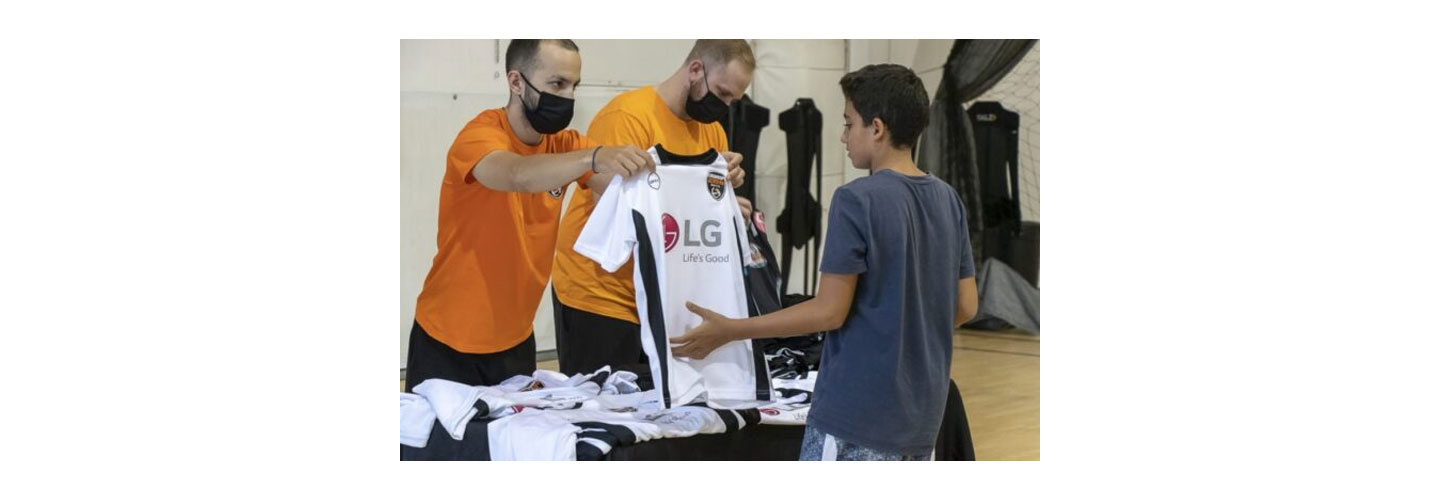 A member of staff giving out LG-sponsored uniforms to participants during the event