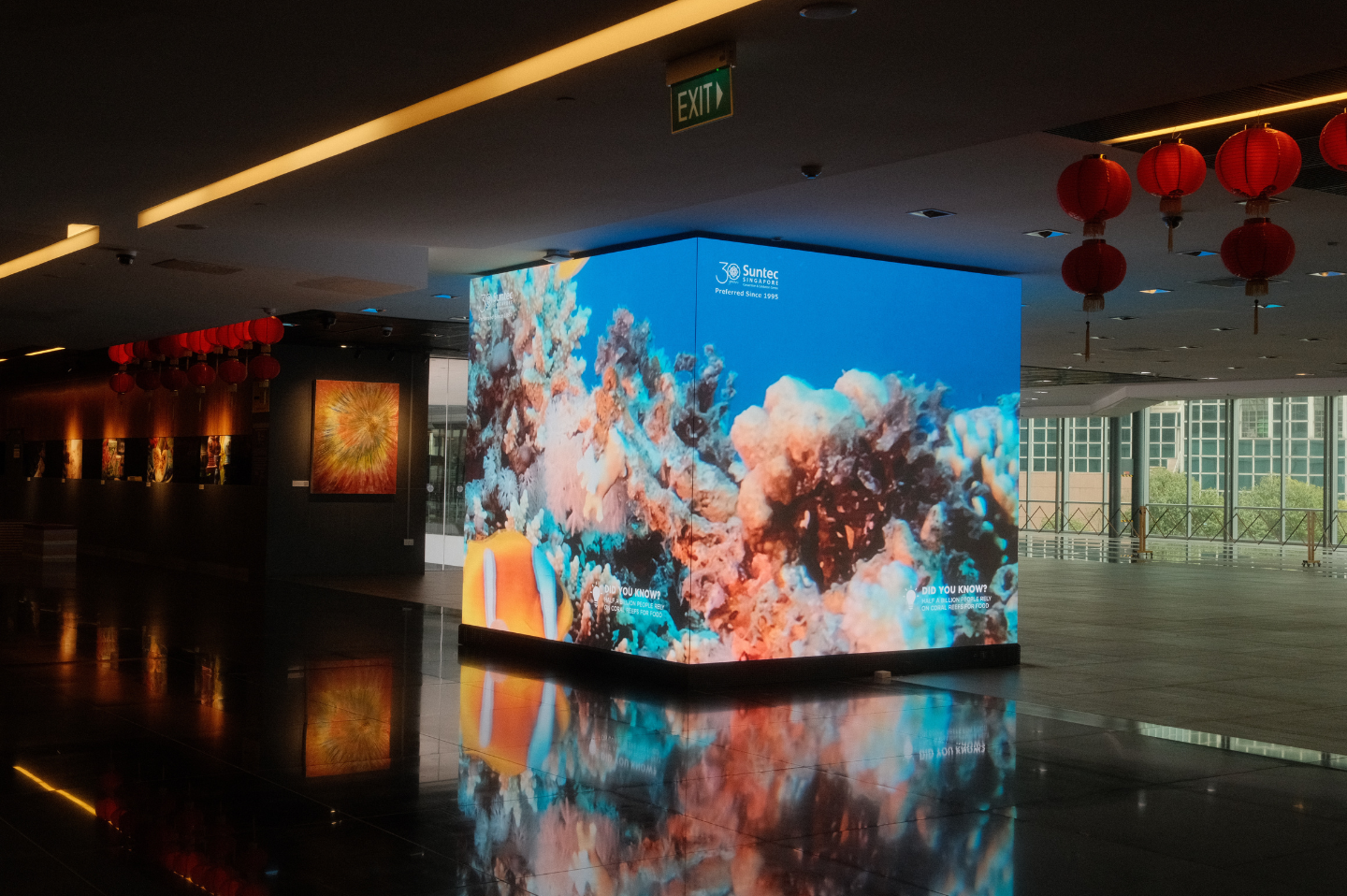An LG LED display at Suntec Singapore lights up the dark hall with a vibrant ocean scene.