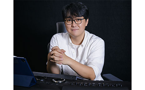 Colorist Park Jin-ho sitting at his work desk which boasts various high-tech electronic equipment