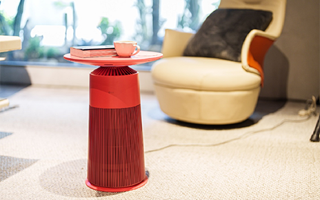 A photo of the LG PuriCare AeroFurniture placed with a book and a cup on top