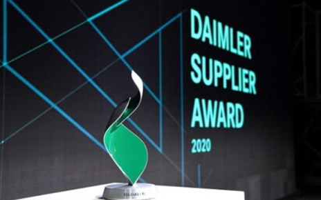 A close-up of the trophy, with the Daimler Supplier Award 2020 Logo displayed behind