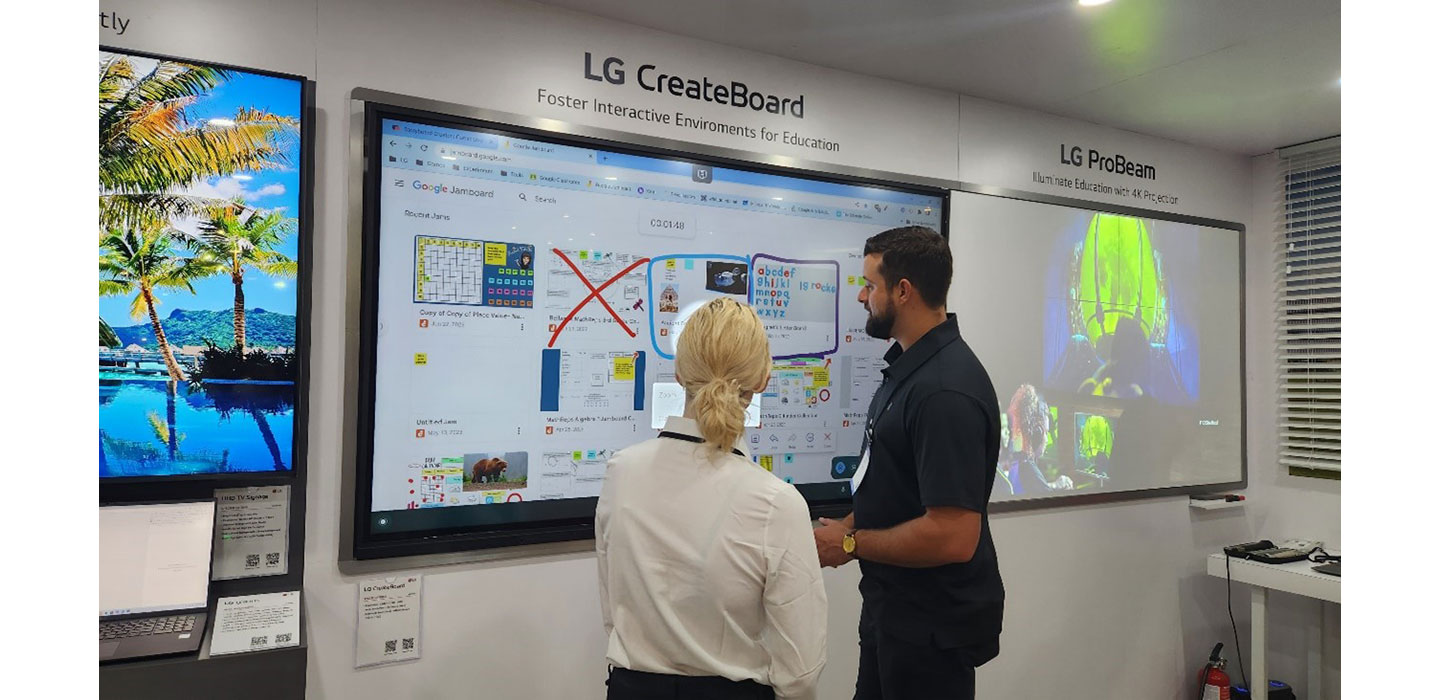 Two people talking in front of LG CreateBoard