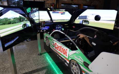 A complete view from the back of someone using the immersive racing simulator