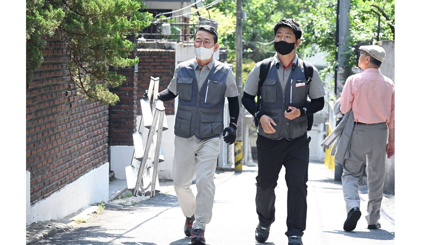 LG CEO walking around districts in Hongdae, Korea, with a ladder in his hand