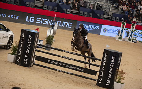 A rider and her horse leap over a tall hurdle at an equestrian competition while the jump displays the LG SIGNATURE logo to highlight the brand as the main sponsor.