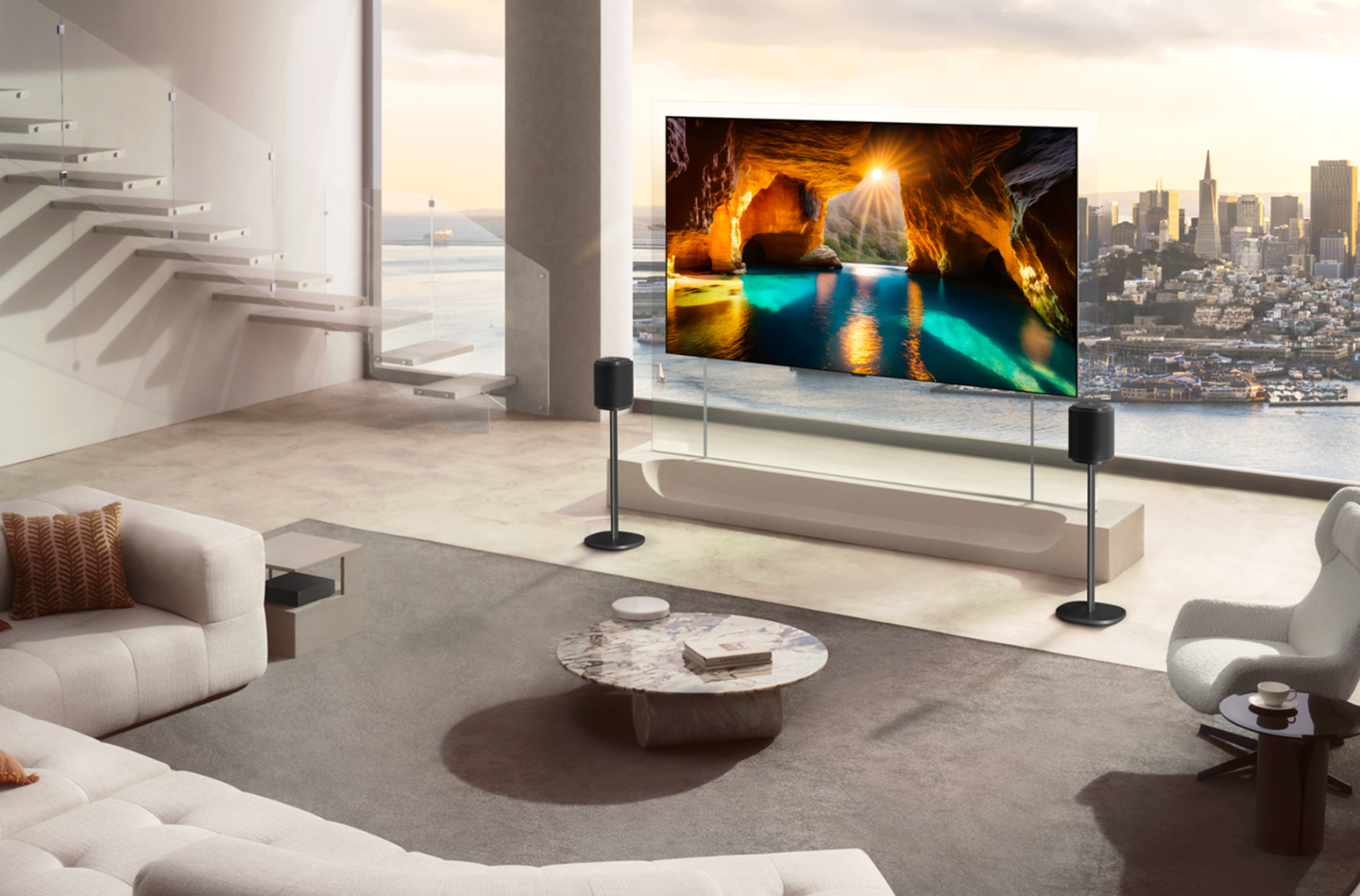 A glowing sea cave is shown on an LG OLED TV attached to a transparent stand, flanked by two speakers in a high-rise living room.