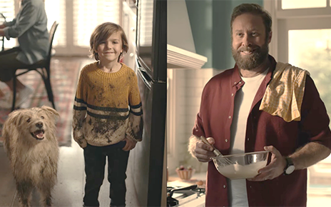 A dad can't help but smile at his son and dog who are both covered in mud.