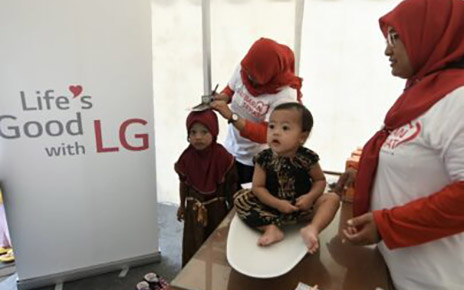 A photo of staff performing a general health checks for children under LG LOVES Indonesia campaign 