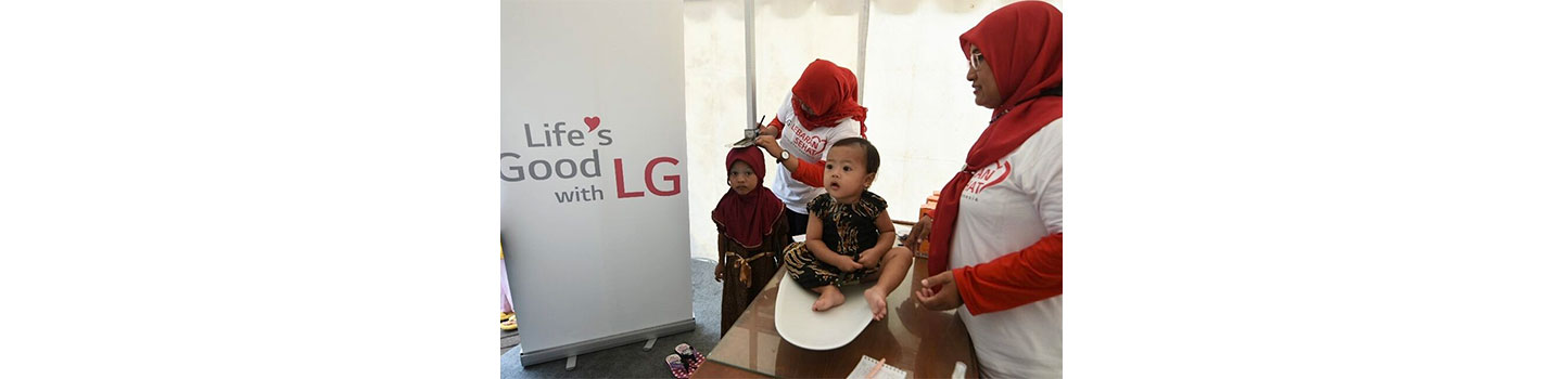 A photo of staff performing a general health checks for children under LG LOVES Indonesia campaign 