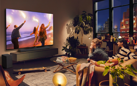 A photo of two women watching television while sitting on a couch